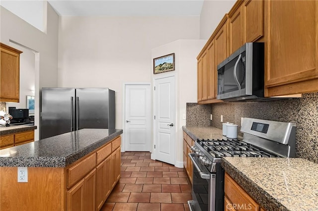 4802 Pentz Rd, Paradise, CA 95969 - kitchen with appliances with stainless steel finishes, backsplash, a center island, and dark tile patterned flooring