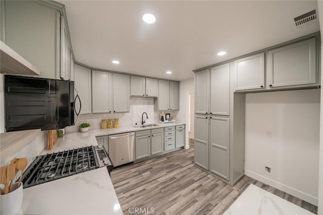 6622 Mitad Ct, San Bernardino, CA 92404 - kitchen with dishwasher, gray cabinets, light wood-style flooring, and recessed lighting