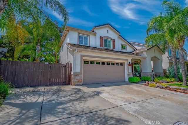 1122 Moonbeam Way, Turlock, CA 95382 - mediterranean / spanish house featuring driveway, stucco siding, stone siding, a garage, and a gate