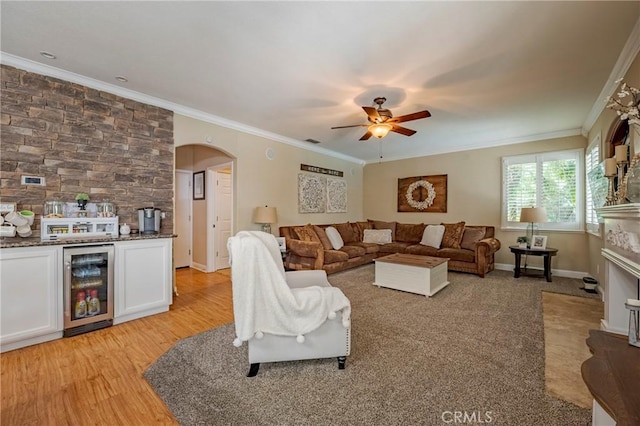 1122 Moonbeam Way, Turlock, CA 95382 - living area with beverage cooler, crown molding, ceiling fan, a fireplace, and arched walkways