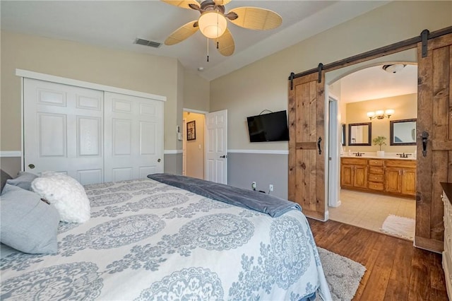 1122 Moonbeam Way, Turlock, CA 95382 - bedroom with a barn door, wood-type flooring, a closet, lofted ceiling, and a ceiling fan