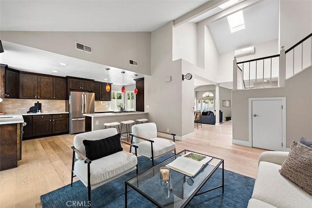 1890 Orange Ave, Costa Mesa, CA 92627 - living room with a wall mounted AC, high vaulted ceiling, light wood-style flooring, and arched walkways