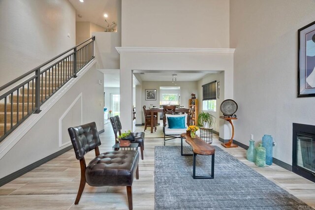 3332 Heather Ridge Ct, San Marcos, CA 92078 - living room featuring light wood-type flooring, a towering ceiling, a fireplace with flush hearth, stairs, and baseboards
