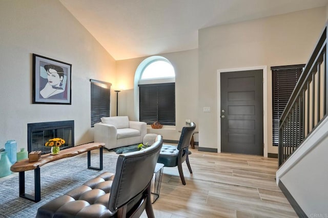 3332 Heather Ridge Ct, San Marcos, CA 92078 - living room featuring lofted ceiling, a glass covered fireplace, light wood-type flooring, baseboards, and stairs