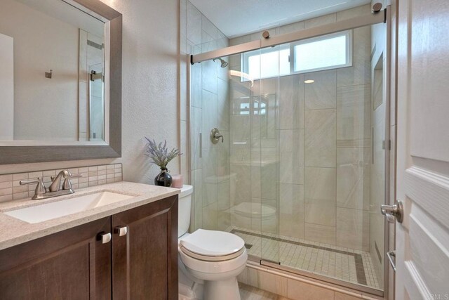 3332 Heather Ridge Ct, San Marcos, CA 92078 - full bathroom featuring toilet, vanity, a shower stall, backsplash, and a textured wall