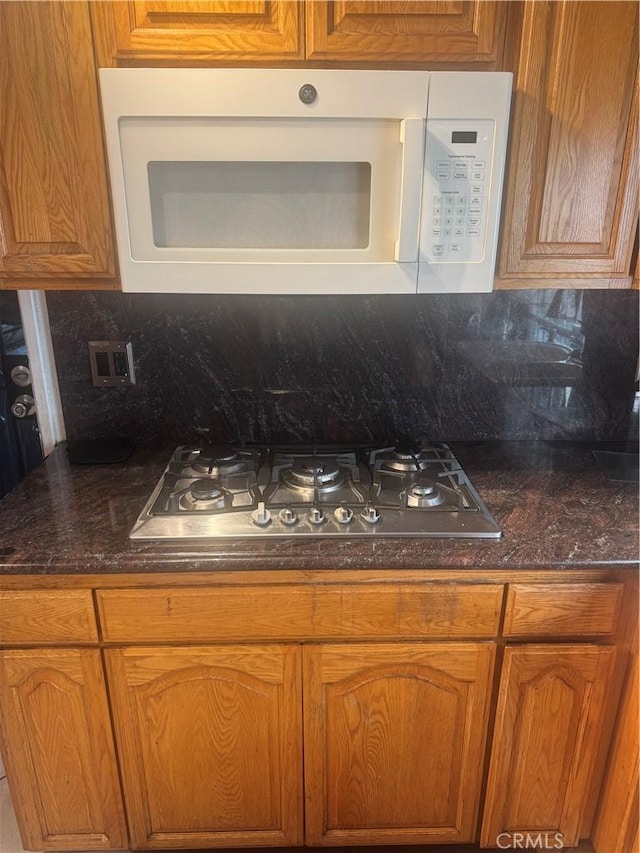 17506 Sandlake Ave, Carson, CA 90746 - kitchen with stainless steel gas stovetop, white microwave, decorative backsplash, and brown cabinets