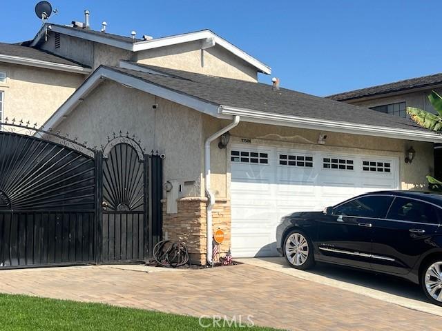 17506 Sandlake Ave, Carson, CA 90746 - view of side of property with a garage, decorative driveway, and stucco siding
