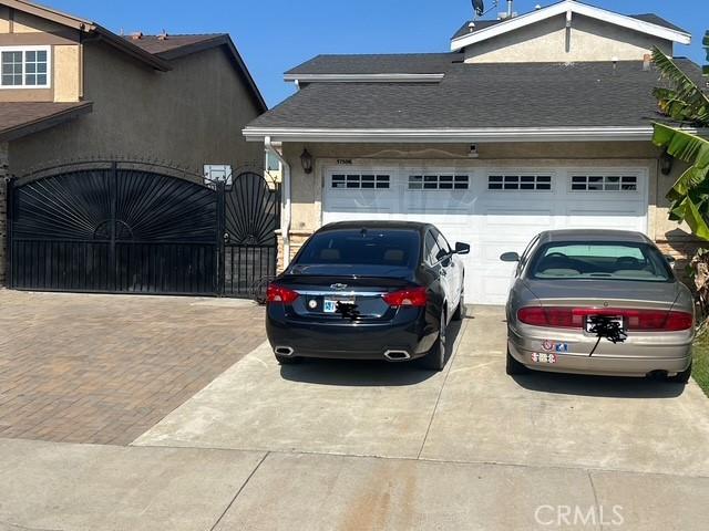 17506 Sandlake Ave, Carson, CA 90746 - view of side of home with concrete driveway, an attached garage, and a gate