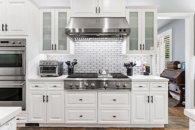 12428 Palmer Dr, Moorpark, CA 93021 - kitchen with stainless steel appliances, range hood, light countertops, white cabinets, and glass insert cabinets