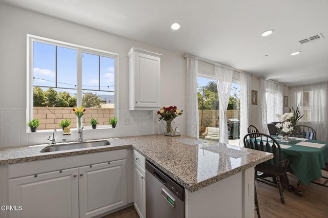275 Fuerte Dr, Santa Paula, CA 93060 - kitchen with dishwasher, white cabinetry, a peninsula, light stone counters, and wood finished floors