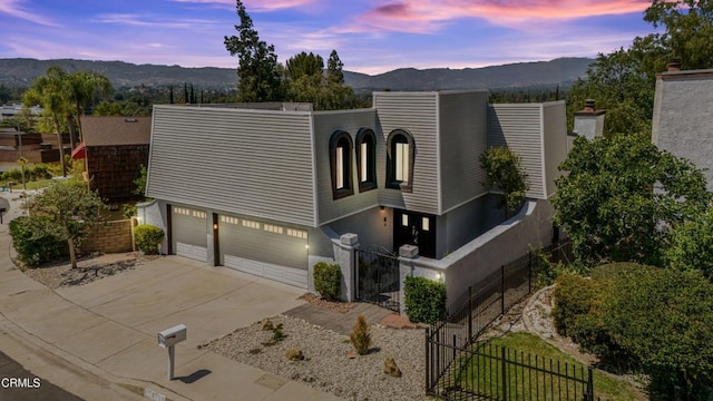 22769 Macfarlane Dr, Woodland Hills, CA 91364 - contemporary house with an attached garage, a mountain view, driveway, and stucco siding