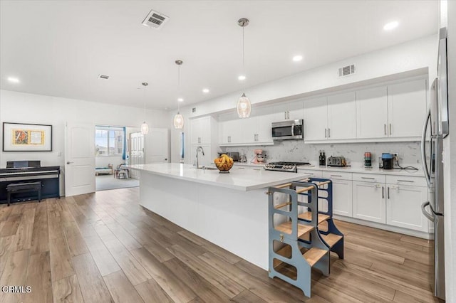 2830 Wagon Wheel Rd Unit 304, Oxnard, CA 93036 - kitchen with stainless steel appliances, light countertops, light wood-style flooring, white cabinetry, and recessed lighting