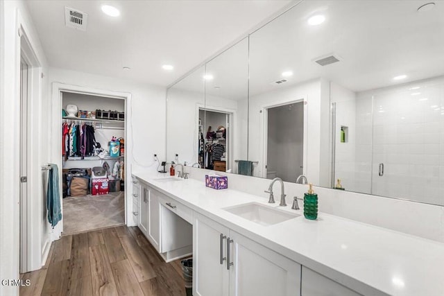 2830 Wagon Wheel Rd Unit 304, Oxnard, CA 93036 - bathroom with a spacious closet, double vanity, wood finished floors, a shower stall, and recessed lighting