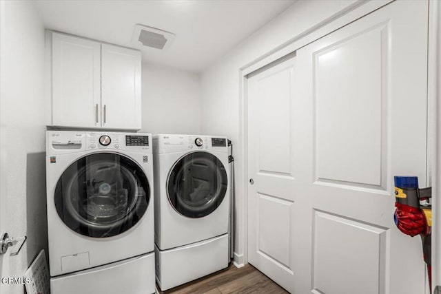 2830 Wagon Wheel Rd Unit 304, Oxnard, CA 93036 - washroom featuring cabinet space, separate washer and dryer, and wood finished floors