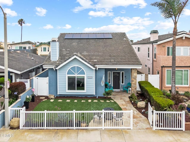 5222 Whitecap St, Oxnard, CA 93035 - view of front facade with a gate, roof mounted solar panels, and a fenced front yard