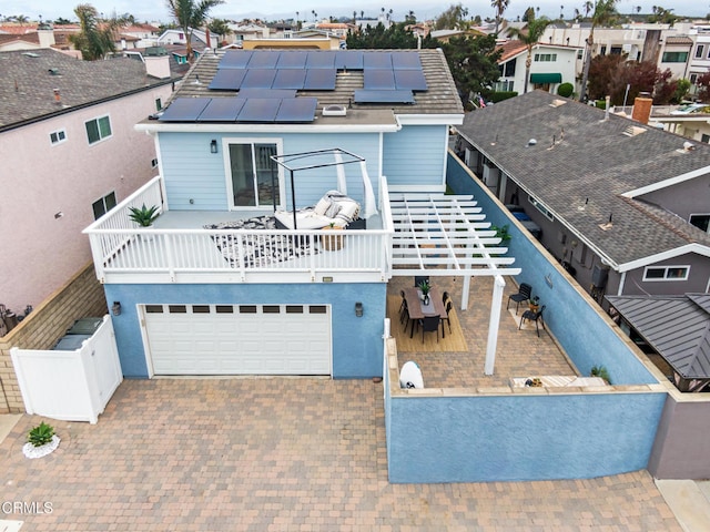 5222 Whitecap St, Oxnard, CA 93035 - back of house featuring roof mounted solar panels, driveway, an attached garage, and a residential view
