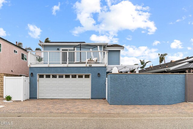 5222 Whitecap St, Oxnard, CA 93035 - view of front facade with a balcony, a garage, decorative driveway, and stucco siding