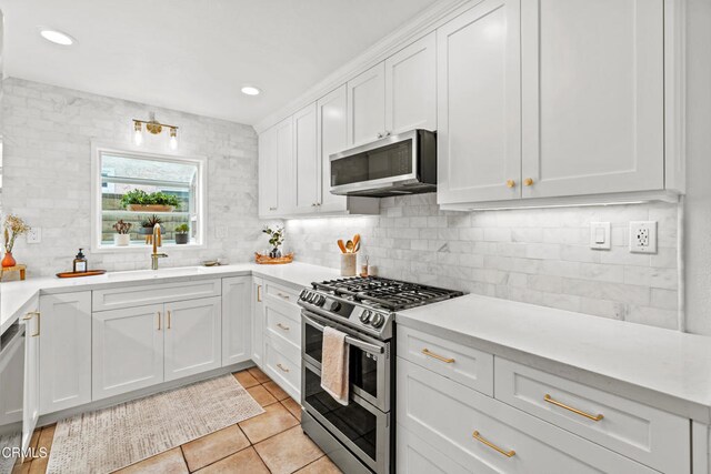 5222 Whitecap St, Oxnard, CA 93035 - kitchen with appliances with stainless steel finishes, tasteful backsplash, light countertops, white cabinets, and light tile patterned floors