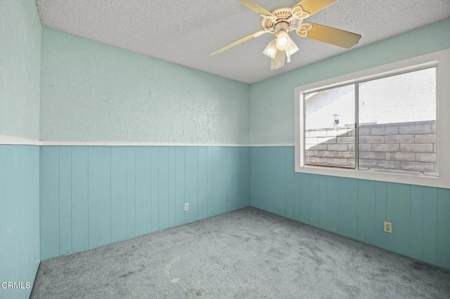5576 Holly Ridge Dr, Camarillo, CA 93012 - carpeted empty room featuring a textured ceiling, ceiling fan, wood walls, and a wainscoted wall