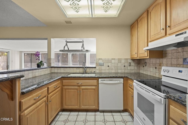 5576 Holly Ridge Dr, Camarillo, CA 93012 - kitchen with white appliances, under cabinet range hood, tasteful backsplash, and dark stone counters