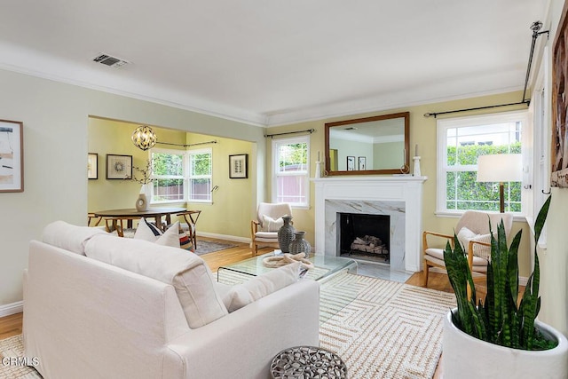 2250 Cooley Pl, Pasadena, CA 91104 - living area with plenty of natural light, crown molding, a fireplace, light wood finished floors, and a chandelier