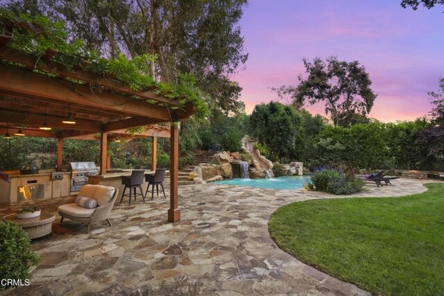 1550 Scenic Dr, Pasadena, CA 91103 - pool at dusk with an outdoor kitchen, a patio, an outdoor pool, a water slide, and a lawn