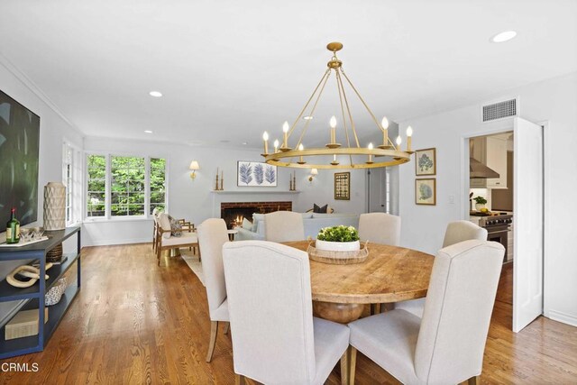 1550 Scenic Dr, Pasadena, CA 91103 - dining area with wood finished floors, a fireplace, a chandelier, recessed lighting, and crown molding