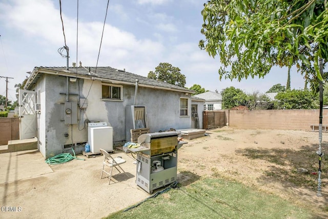 15207 Lorne St, Panorama City, CA 91402 - rear view of property featuring a fenced backyard, washer / clothes dryer, stucco siding, a patio area, and a shingled roof