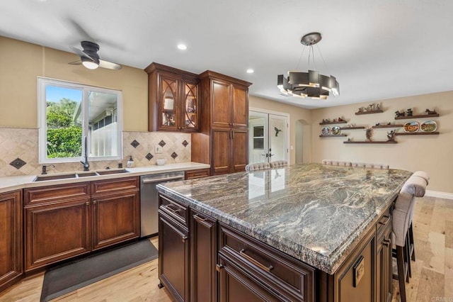525 Hilo Way, Vista, CA 92081 - kitchen featuring stainless steel dishwasher, light wood-style floors, ceiling fan, tasteful backsplash, and a breakfast bar area