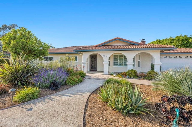525 Hilo Way, Vista, CA 92081 - mediterranean / spanish house with stucco siding, a tile roof, a garage, and a chimney