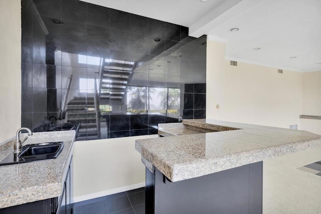 1138 Via Mil Cumbres, Solana Beach, CA 92075 - kitchen featuring dark cabinetry, dark tile patterned floors, ornamental molding, and light countertops