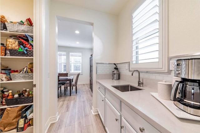 35909 Shetland Hls E, Fallbrook, CA 92028 - kitchen with light countertops, white cabinetry, backsplash, light wood-type flooring, and recessed lighting