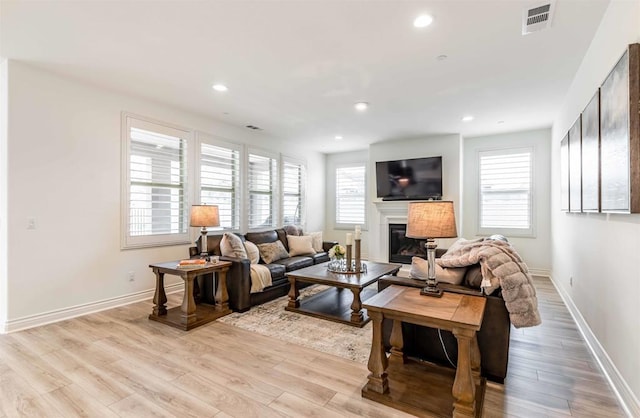 35909 Shetland Hls E, Fallbrook, CA 92028 - living room featuring healthy amount of natural light, a glass covered fireplace, light wood-style floors, and recessed lighting