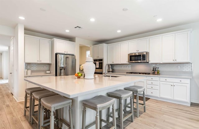 35909 Shetland Hls E, Fallbrook, CA 92028 - kitchen with stainless steel appliances, light wood-type flooring, white cabinets, backsplash, and recessed lighting