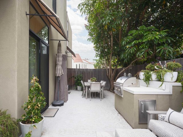 265 Coast Blvd Unit 9, La Jolla, CA 92037 - fenced backyard with outdoor dining area, an outdoor kitchen, and a patio area