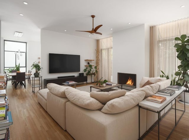 265 Coast Blvd Unit 9, La Jolla, CA 92037 - living room with recessed lighting, a warm lit fireplace, wood finished floors, and ceiling fan