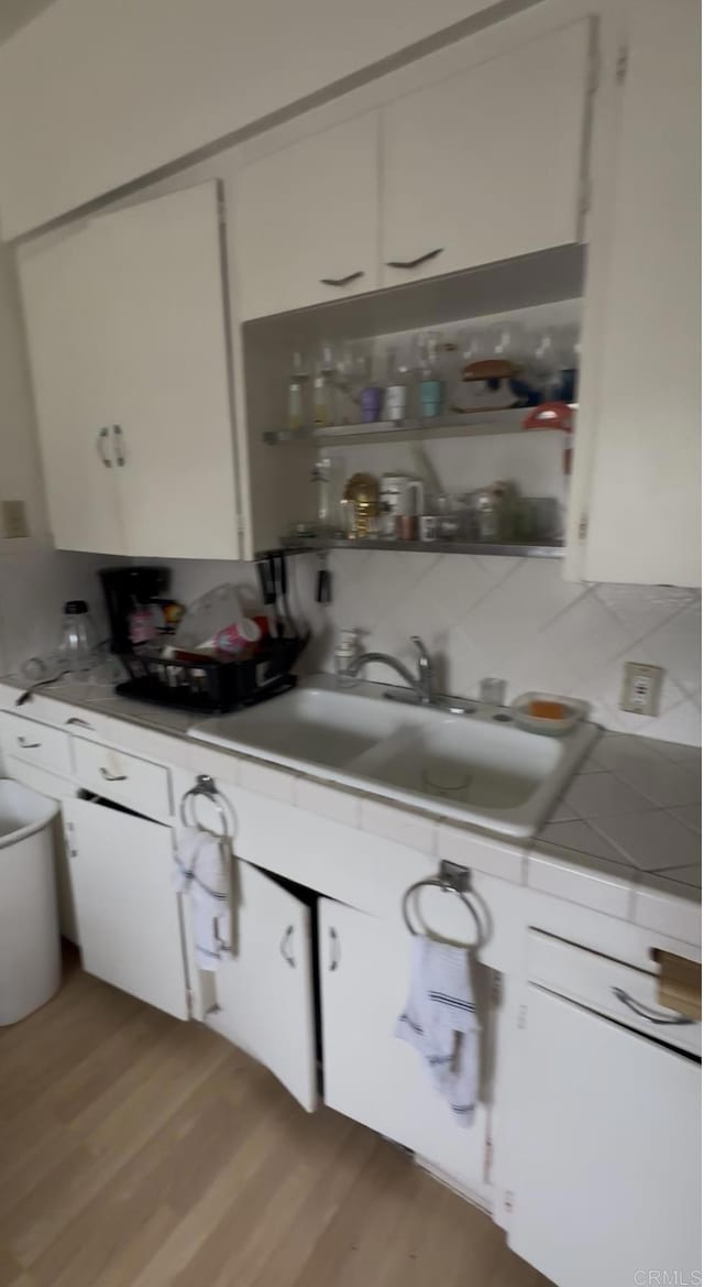 3766 King Ln, Mesa, CA 91941 - kitchen featuring white cabinetry, light wood-style floors, and tasteful backsplash