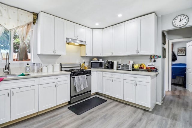 1947 D Ave, National City, CA 91950 - kitchen featuring appliances with stainless steel finishes, under cabinet range hood, light countertops, white cabinets, and recessed lighting