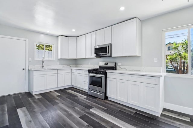 1947 D Ave, National City, CA 91950 - kitchen with stainless steel appliances, white cabinets, recessed lighting, dark wood-style floors, and light stone counters