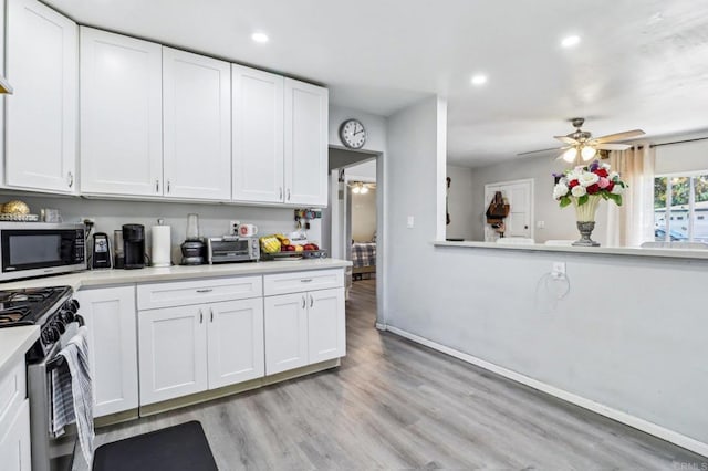 1947 D Ave, National City, CA 91950 - kitchen with range with gas stovetop, stainless steel microwave, ceiling fan, light countertops, and light wood finished floors