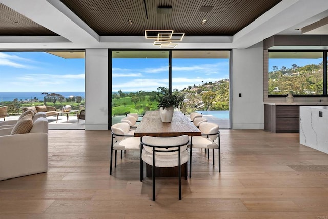 6627 Muirlands Dr, La Jolla, CA 92037 - dining space with a wall of windows, a raised ceiling, light wood-style floors, and plenty of natural light