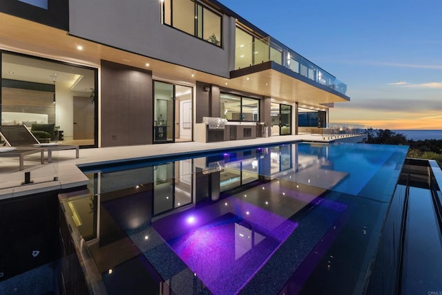 6627 Muirlands Dr, La Jolla, CA 92037 - pool at dusk with an outdoor kitchen and a patio