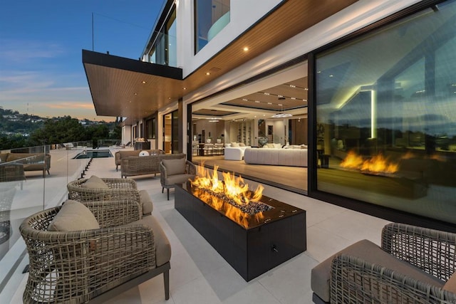 6627 Muirlands Dr, La Jolla, CA 92037 - patio terrace at dusk with an outdoor living space with a fire pit, a patio area, and an outdoor pool