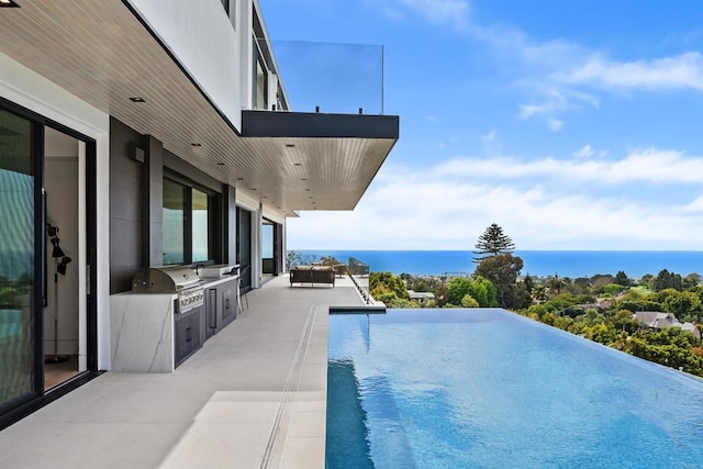 6627 Muirlands Dr, La Jolla, CA 92037 - view of swimming pool featuring an outdoor kitchen, a patio, an infinity pool, and a water view