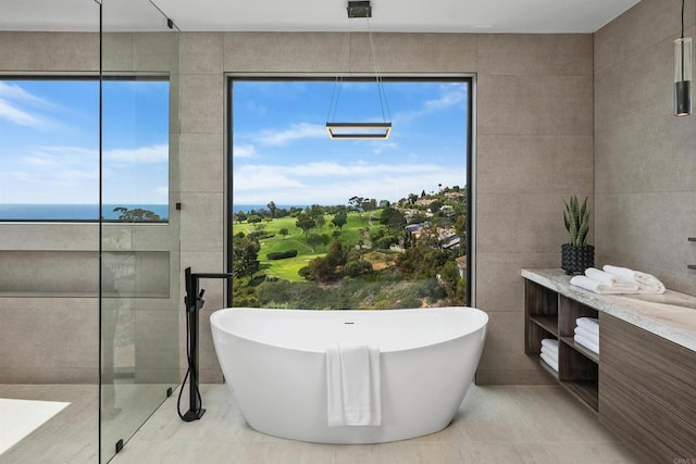 6627 Muirlands Dr, La Jolla, CA 92037 - full bathroom featuring tile walls, a soaking tub, tile patterned flooring, vanity, and view of golf course