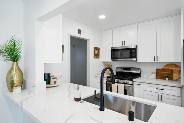 1472 Loma Ln, Chula Vista, CA 91911 - kitchen featuring stainless steel appliances, white cabinetry, light stone countertops, and recessed lighting