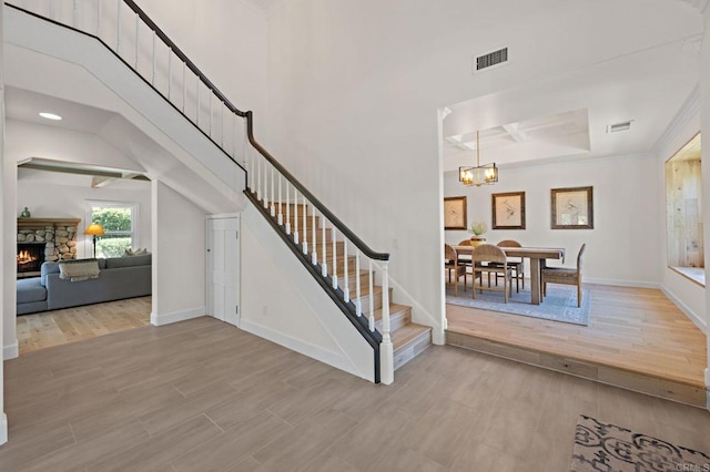 18 Gateview Dr, Fallbrook, CA 92028 - staircase with a chandelier, wood finished floors, a stone fireplace, a tray ceiling, and recessed lighting