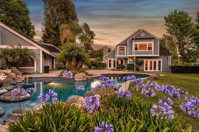 18 Gateview Dr, Fallbrook, CA 92028 - pool at dusk with french doors, an outdoor pool, a patio, and a lawn