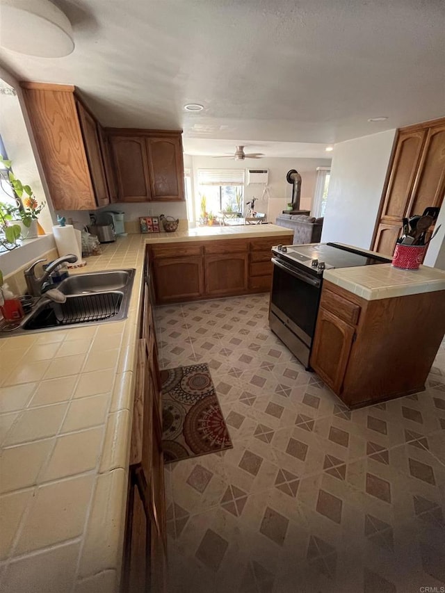 8606 Valley View Trl, Pine Valley, CA 91962 - kitchen featuring tile counters, a peninsula, electric range, brown cabinets, and ceiling fan