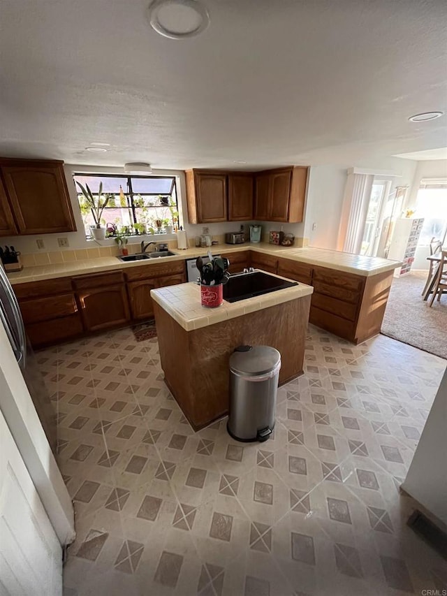 8606 Valley View Trl, Pine Valley, CA 91962 - kitchen featuring tile countertops, a center island, a peninsula, black electric cooktop, and brown cabinets